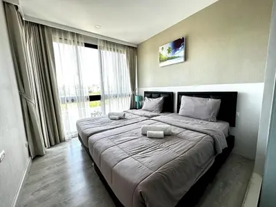 a large bed in a room with a large window at Royal Lee Airport Phuket in Ban Bo Han