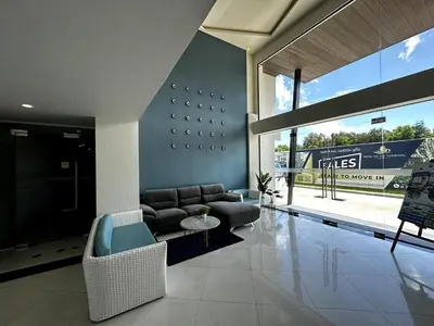 a living room with a couch and a tv at Royal Lee Airport Phuket in Ban Bo Han