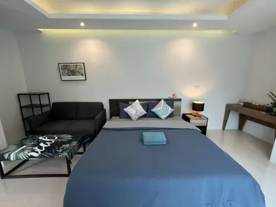 a bedroom with a large bed and a couch at 3bedrooms pool Villa in Kamala in Kamala Beach