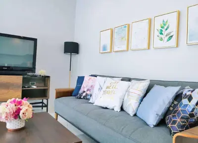 a living room with a couch with pillows and a tv at 3bedrooms pool Villa in Kamala in Kamala Beach
