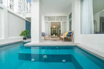 a house with a swimming pool with a table and chairs at 7BR Patong pool villa in Patong Beach
