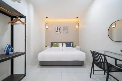 a bedroom with a bed and a desk and a mirror at 7BR Patong pool villa in Patong Beach