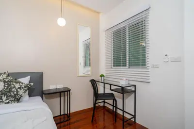 a bedroom with a desk and a bed and windows at 7BR Patong pool villa in Patong Beach