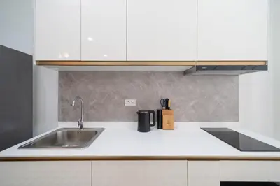 a kitchen counter with a sink and white cabinets at 7BR Patong pool villa in Patong Beach