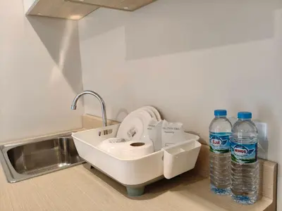 a sink with two bottles of water on a counter at Le Wadee Residence in Bang Tao Beach