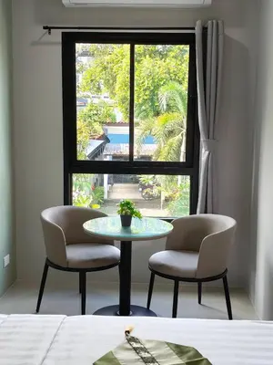 a table and two chairs in a room with a window at Le Wadee Residence in Bang Tao Beach