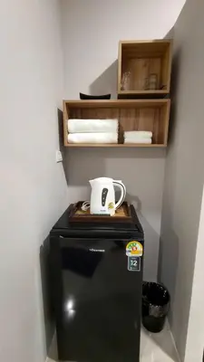 a coffee cup sitting on top of a refrigerator at Le Wadee Residence in Bang Tao Beach