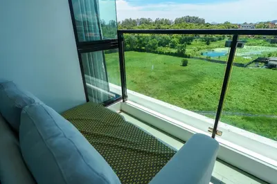 a living room with a couch and a large window at New 1 Bdr Royal Lee Nayang beach in Ban Bo Han