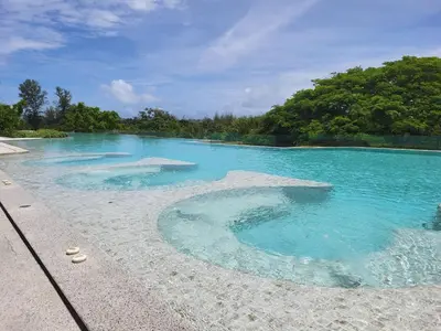 a pool of blue water with trees in the background at Laguna Residence, Pool View in Bang Tao Beach