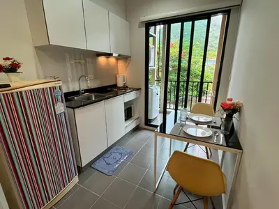 a kitchen with a refrigerator and a table with chairs at ห้องวิวเขา in Ban Ket Ho