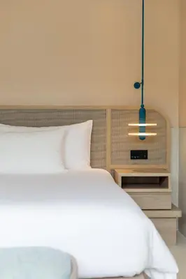 a bedroom with a white bed and a pendant light at Centara Karon Villas Phuket in Karon Beach