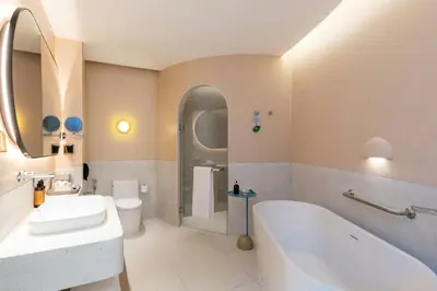 a bathroom with a tub and a sink and a toilet at Centara Karon Villas Phuket in Karon Beach