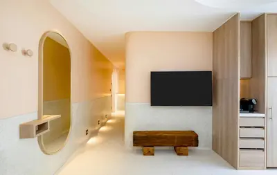 a living room with a tv and a bench at Centara Karon Villas Phuket in Karon Beach