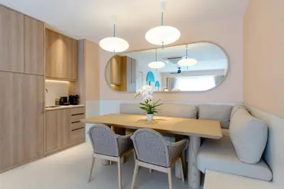 a dining room with a table and chairs and a mirror at Centara Karon Villas Phuket in Karon Beach