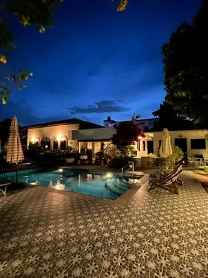 a swimming pool in front of a house at night at Green View suite with private bathroom and kitchen in Ban Phlu Yai