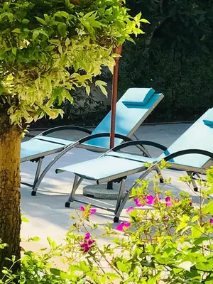 a group of chairs sitting next to a tree at Green View suite with private bathroom and kitchen in Ban Phlu Yai