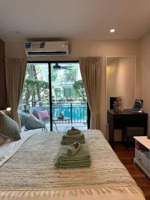 a bedroom with a bed with two towels on it at Pool Access Beachfront Studio in Phuket Town