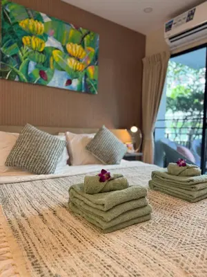 a hotel room with two towels on a bed at Pool Access Beachfront Studio in Phuket Town