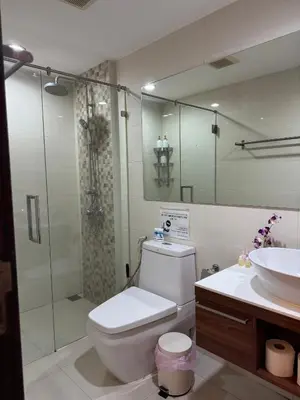 a bathroom with a shower and a toilet and a sink at Pool Access Beachfront Studio in Phuket Town