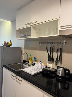 a kitchen with a sink and a dish rack with utensils at Pool Access Beachfront Studio in Phuket Town