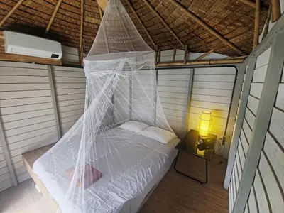 a bed in a room with a mosquito net at Krabi Sea view, Lilly Beach Room Balibar in Krabi town