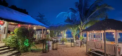 a resort with tables and chairs and a palm tree at Krabi Sea view, Lilly Beach Room Balibar in Krabi town