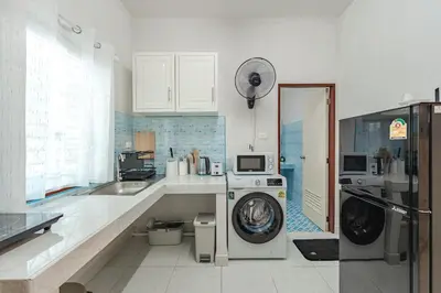 a kitchen with a washing machine and a washer at The Coastal Haven Holiday Home, Karon Beach in Karon Beach