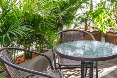a glass table and chairs in front of plants at The Coastal Haven Holiday Home, Karon Beach in Karon Beach