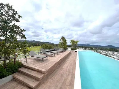 a swimming pool with chaise lounge chairs on top of a building at Sky park, 2 bed Besthome98 in Laguna Phuket