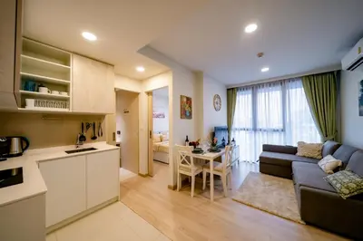 a kitchen and living room with a couch and a table at Sky park, 2 bed Besthome98 in Laguna Phuket