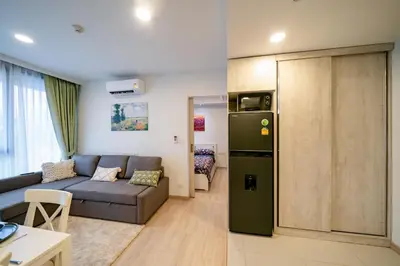 a living room with a couch and a refrigerator at Sky park, 2 bed Besthome98 in Laguna Phuket