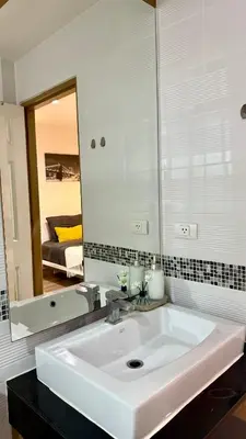 a bathroom with a sink and a large mirror at Apartment with a view near the park in Ban Rangeng