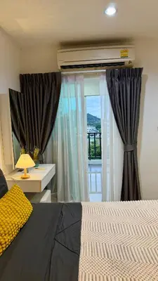 a bedroom with a bed and a window with curtains at Apartment with a view near the park in Ban Rangeng