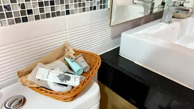 a basket of towels sitting on top of a toilet in a bathroom at Apartment with a view near the park in Ban Rangeng