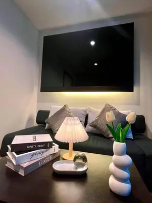 a living room with a couch and a table with a lamp at Apartment with a view near the park in Ban Rangeng