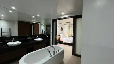 a bathroom with a tub and two sinks and a bedroom at Tranquil 2-Bedroom Getaway - Celeena #870 in Rawai Beach
