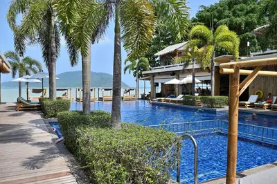 a swimming pool with palm trees and a resort at Tranquil 2-Bedroom Getaway - Celeena #870 in Rawai Beach