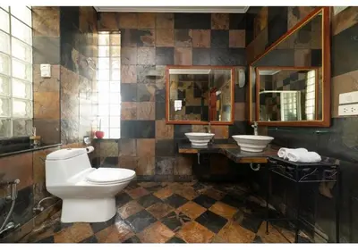 a bathroom with a toilet and two sinks at Lumaya Rawai in Rawai Beach