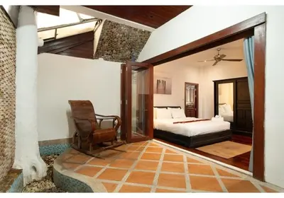 a bedroom with a bed and a chair in it at Lumaya Rawai in Rawai Beach