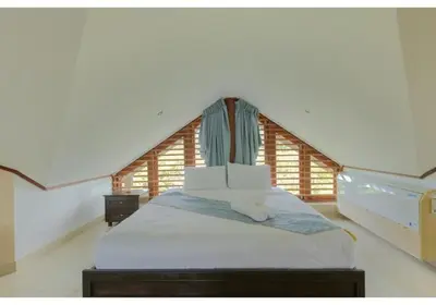 a bedroom with a bed in a room with windows at Lumaya Rawai in Rawai Beach