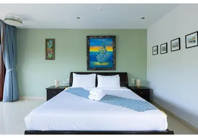 a bedroom with a large bed with a teddy bear on it at Lumaya Rawai in Rawai Beach