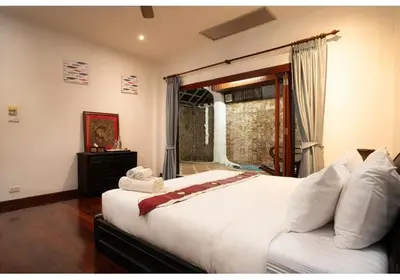 a bedroom with a large white bed with a window at Lumaya Rawai in Rawai Beach