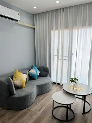 a living room with a couch and a table at UPMOON Hotel Chalong Phuket in Ban Suan