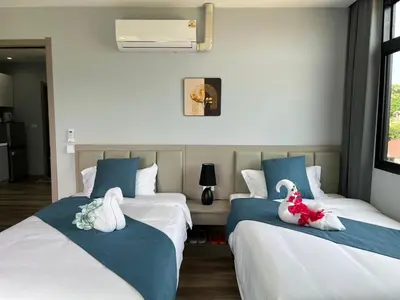 two beds in a room with blue and white at UPMOON Hotel Chalong Phuket in Ban Suan