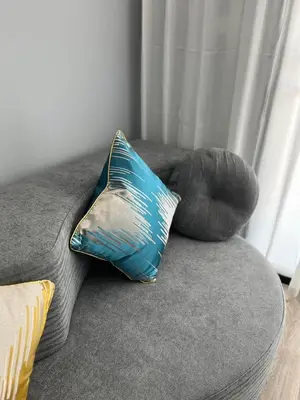 a blue pillow sitting on a gray couch at UPMOON Hotel Chalong Phuket in Ban Suan