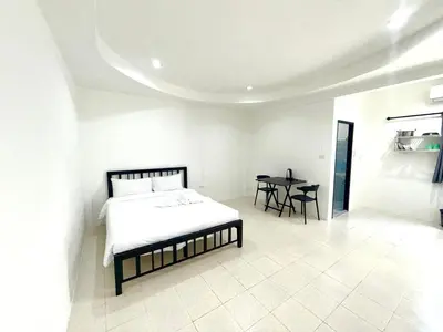 a bedroom with a bed and a table in it at Patong Canal Villa 102 in Patong Beach