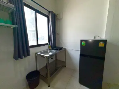 a small kitchen with a small table and a refrigerator at Patong Canal Villa 102 in Patong Beach