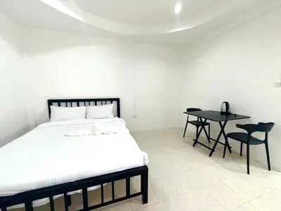 a bedroom with a bed and a table with chairs at Patong Canal Villa 102 in Patong Beach
