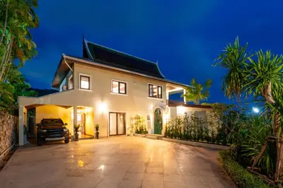a white house with a driveway at night at Villa Melita 5 bedrooms, hillside location with pool and seaview in Kata Beach