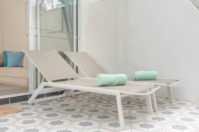 a white bench with two pillows on a patio at Loft with pool & patio - 8 min to Rawai beach - 